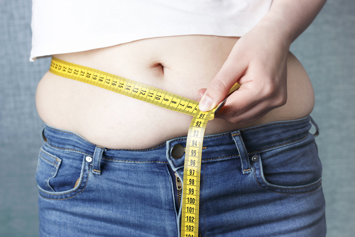 肥満体型の女性、メジャーで腹部を計測